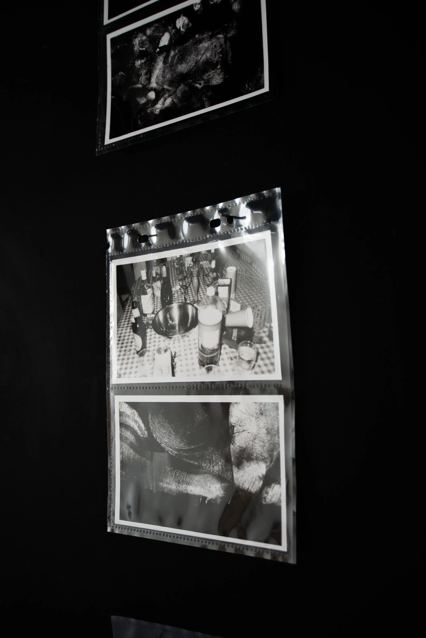 Darkroom prints hung in archival plastic pockets, 15 × 10 cm each.