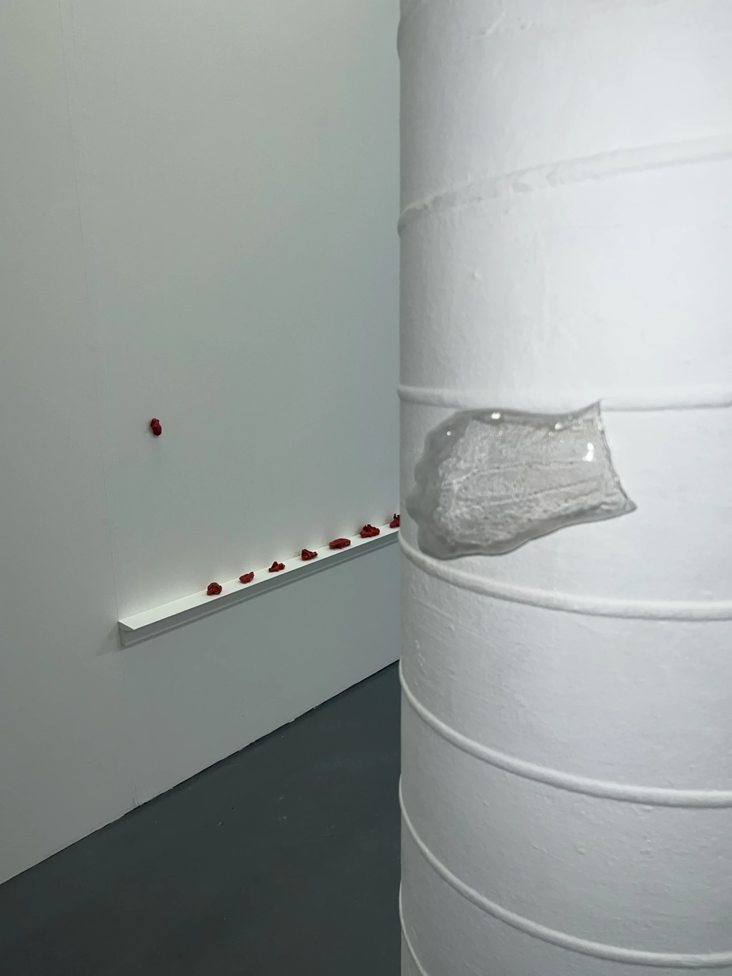 Installation view, transparent hand on pillar and shelf with clay pieces, NCAD Works 2026.
