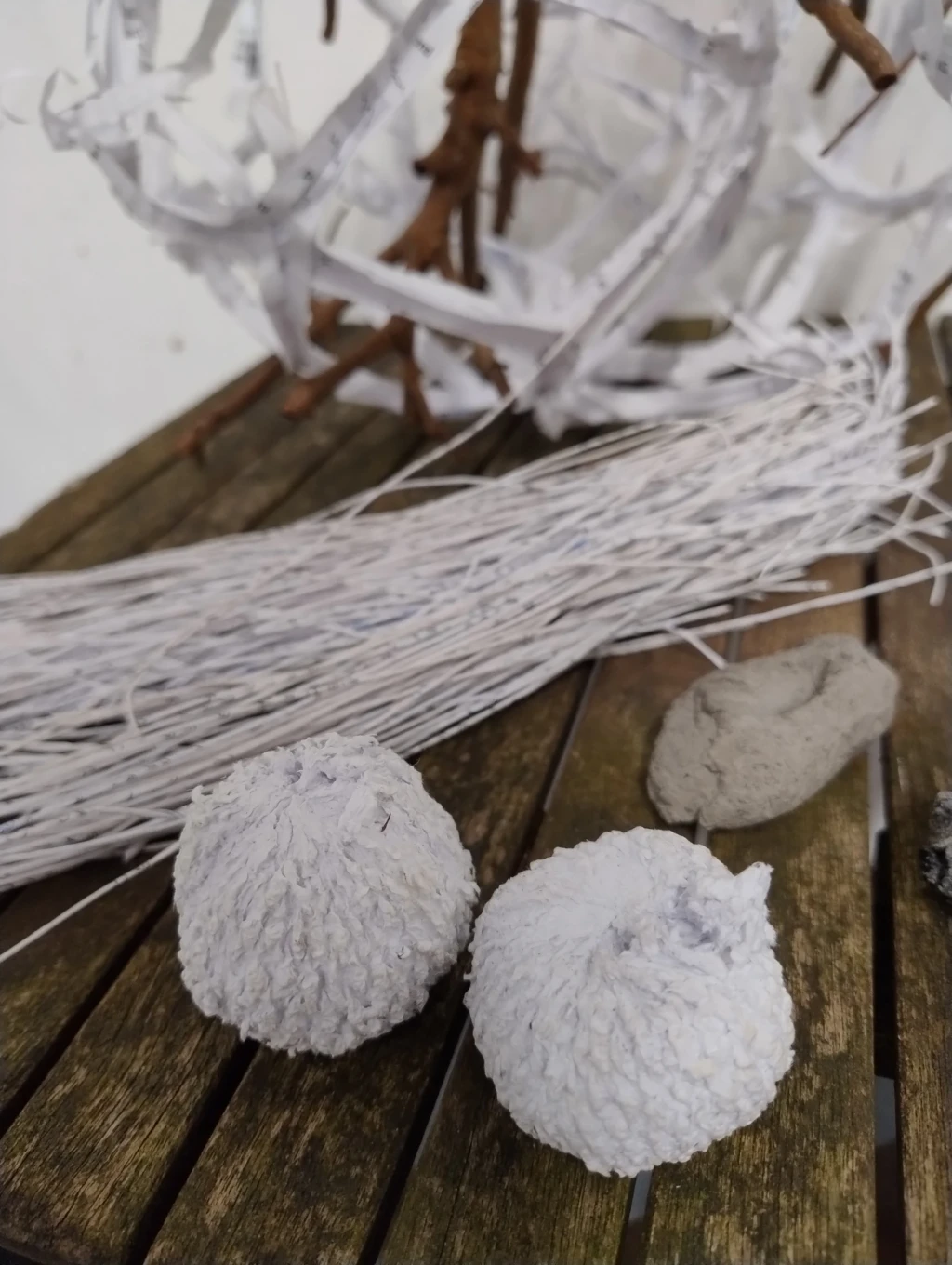 Paper threads and textured paper pulp balls.