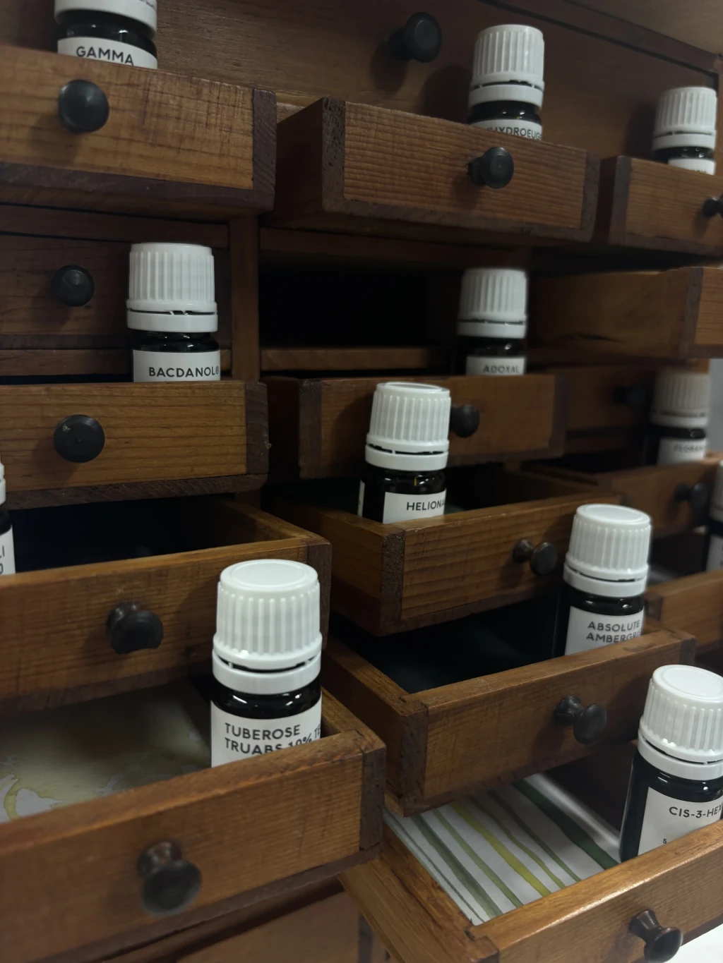 Aromachemicals inside shelves with illustrated scent cards.