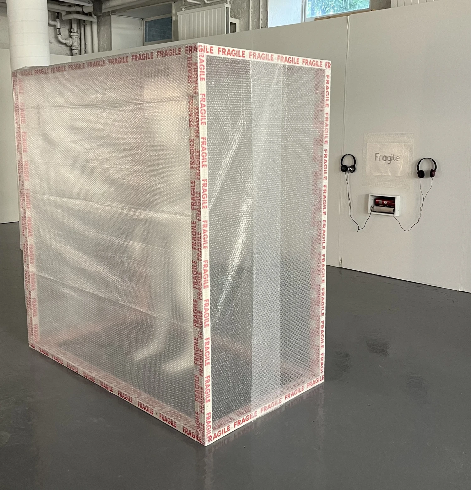 Mixed-media installation, wooden structure, bubble wrap, projection, fragile tape and sound, 170 x 160 x 80cm.