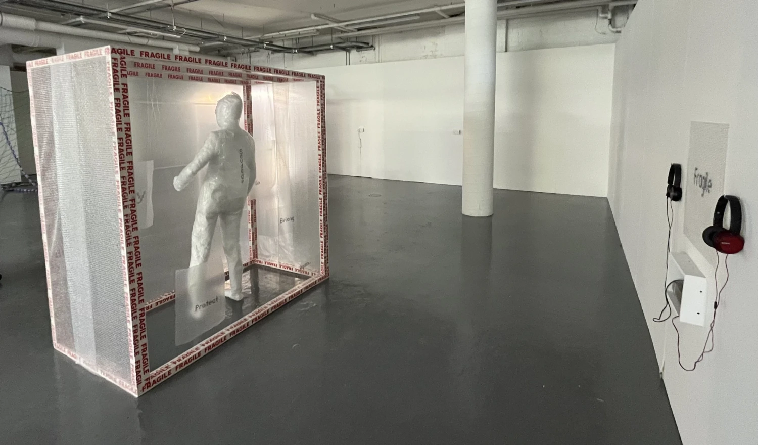 Installation view showing body cast, layered materials and spatial arrangement.