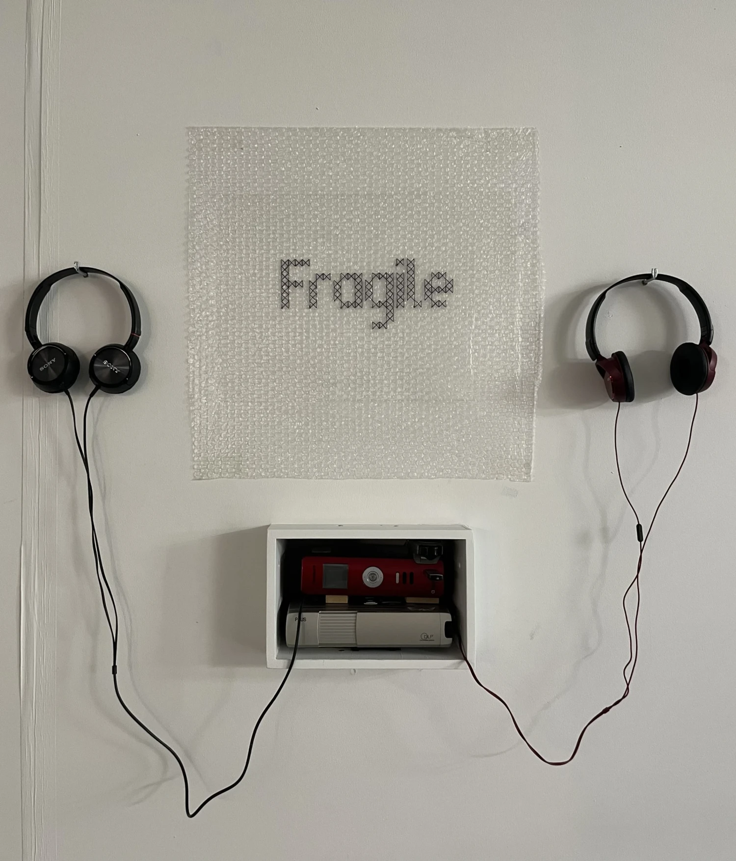 Sound element including multimedia player, headphones and stitched bubble wrap piece.