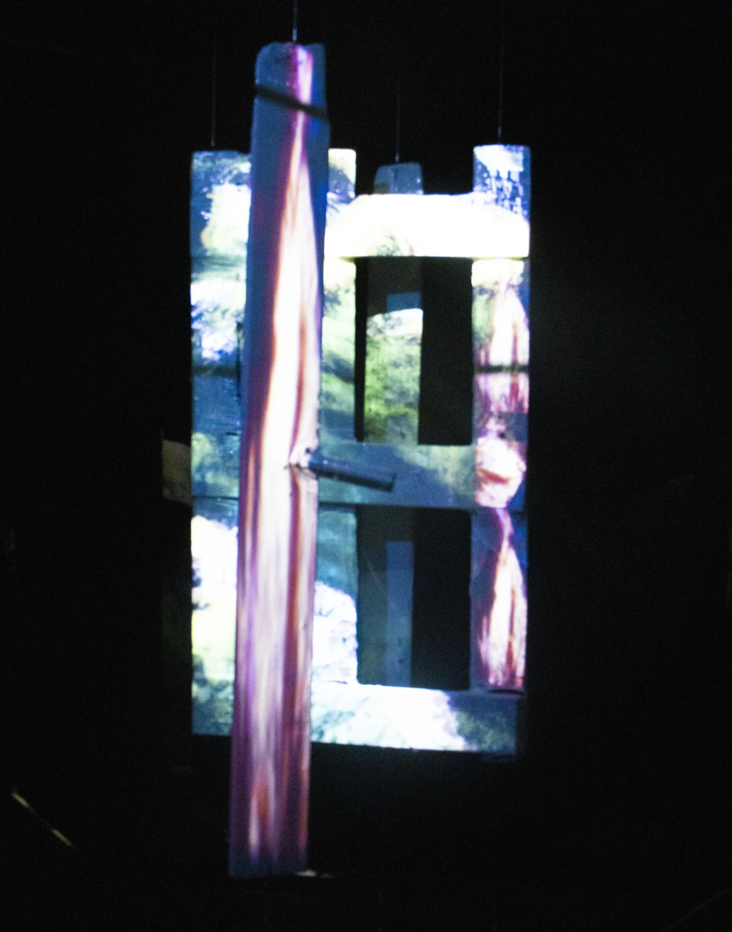 Close-up installation view, decaying wooden door, melted plastic wrap, steel wire, projection mapping.