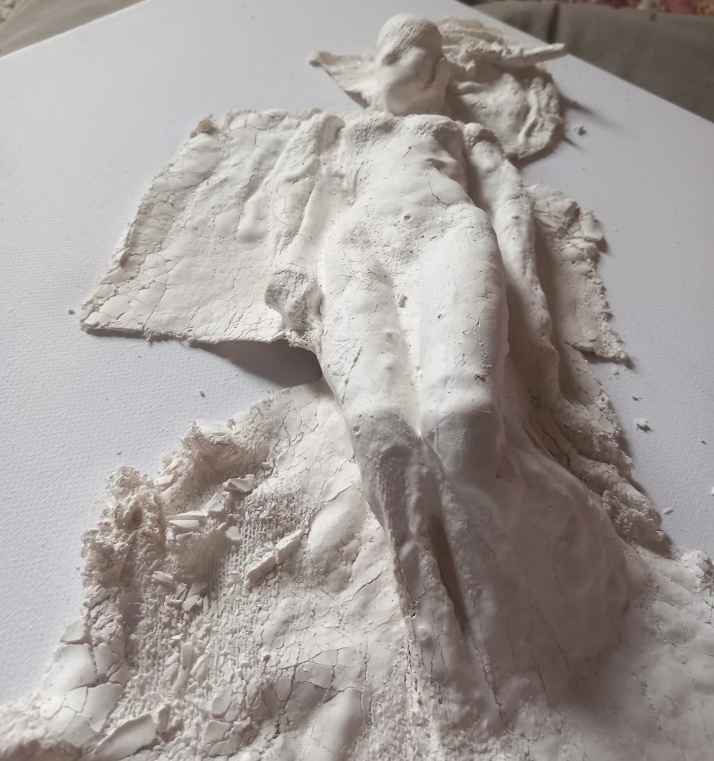 Fabric dipped in plaster draped over female form and hung to dry.