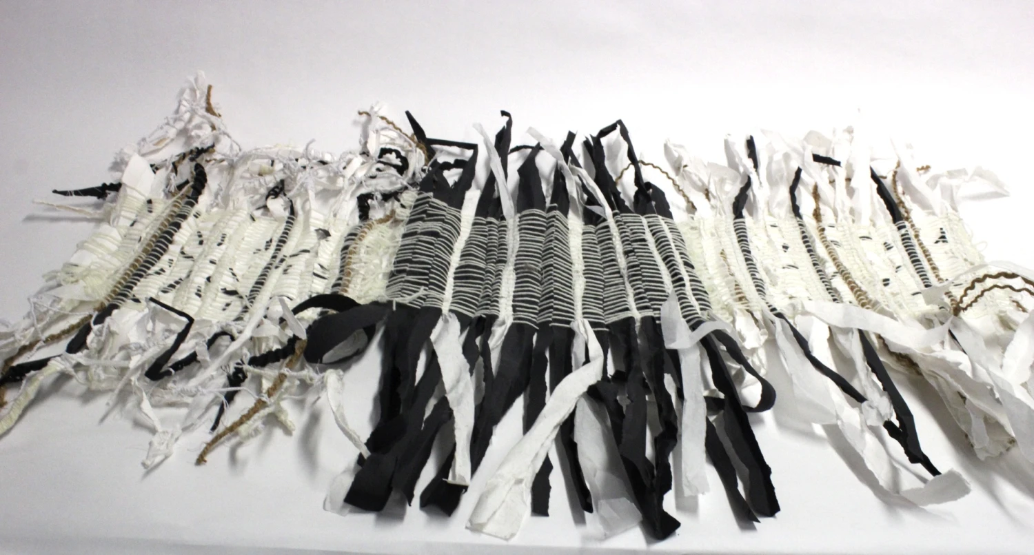 Scroll of black and white Fabriano paper, woven in the loom with string, silk cord, cotton, wool and paper wires, 120 x 60 cm.
