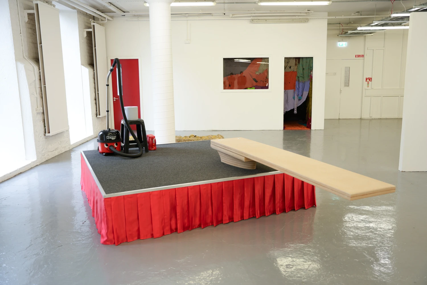 *Everyone Is Secretly Expecting That Something Beautiful Will Happen to Them*, carpet tiles, polyester fabric, aluminium, MDF, Henry hoover, blue centre feed roll, Lucozade, plastic stool.