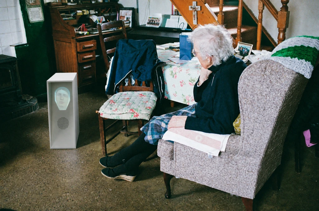 Máire Begley, traditional musician and cultural advocate, listens to stories held by the robot and shares stories of her own.