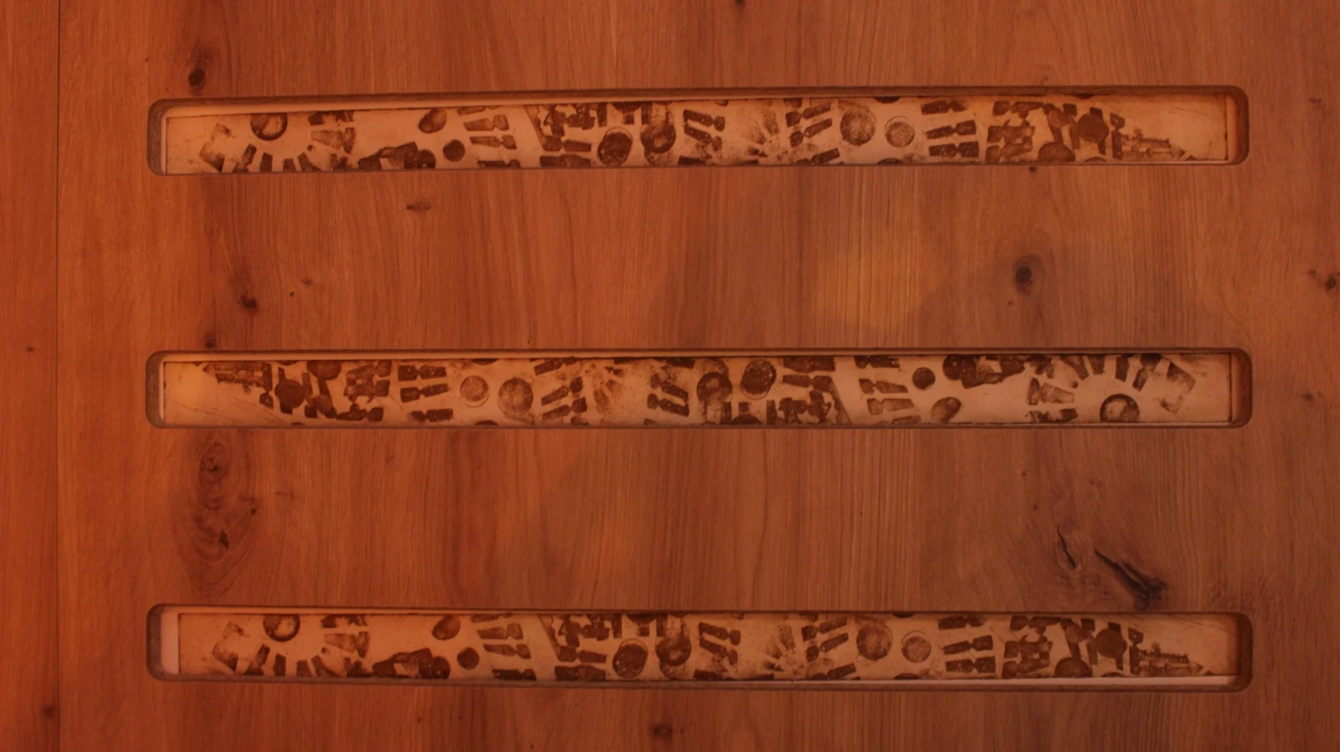 *The Weight of a Step*, wooden slats interrupt the space, carrying traces of movement through etched boot imprints, 155 x 155 cm.
